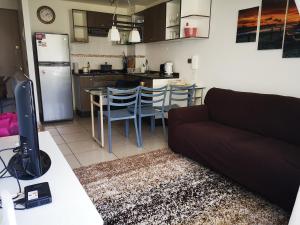a living room with a couch and a kitchen at Espectacular departamento amoblado en Algarrobo Norte in San Antonio