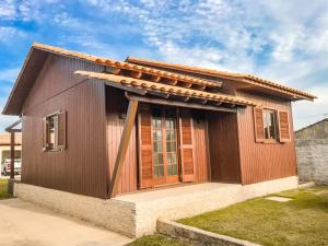 ein kleines Holzhaus mit einem Dach in der Unterkunft Casa Aconchegante com Privacidade em Balneário Rincão in Aliatar