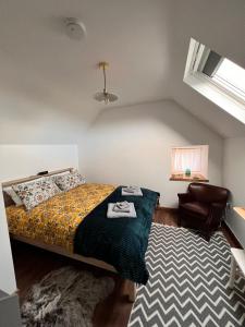 1 dormitorio con 1 cama y 1 silla en Wild Wild West Holiday Cottages, en Castletownbere