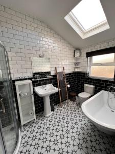 Baño en blanco y negro con lavabo y aseo en Wild Wild West Holiday Cottages, en Castletownbere