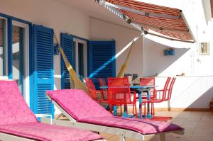 カスカイスにあるGreat Terrace Valbom Apartmentの赤い椅子とテーブル、青いドア付きのパティオ