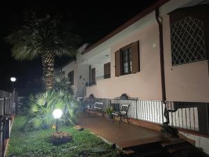 weranda domu z dwoma krzesłami i palmą w obiekcie Villa Antonella w mieście Pozzilli