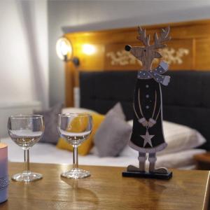una statua di una renna con due bicchieri di vino sul tavolo di Willa Mamcorka a Poronin