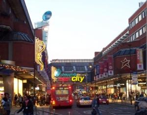 a red double decker bus driving down a city street at Luxury 1 bedroom flat in the heart of Wood Green in London