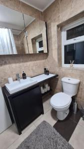 a bathroom with a toilet and a sink and a mirror at Luxury 1 bedroom flat in the heart of Wood Green in London