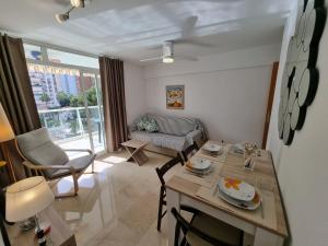 un piccolo soggiorno con tavolo e sedie di Ideal familias en urbanización de lujo a 600m de la playa Levante con Wifi, AC y Parking a Benidorm