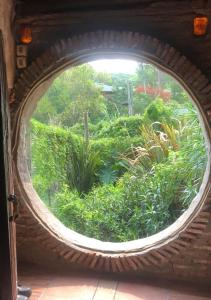 ein rundes Fenster mit Gartenblick in der Unterkunft Casa Hobbit in Salinas