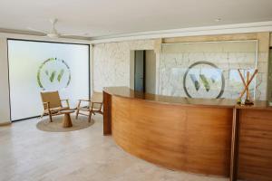 a lobby with a wooden reception desk and chairs at The Waves Tulum in Tulum