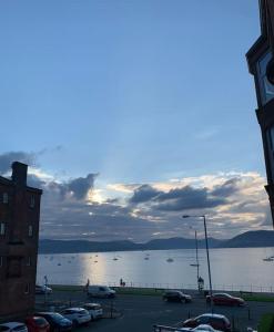 a parking lot next to a large body of water at Lovely flat overlooking the Clyde in Gourock