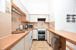 uma cozinha com um lavatório e um fogão forno superior em Lovely flat overlooking the Clyde em Gourock
