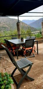 einen Tisch und Stühle auf einer Terrasse mit Aussicht in der Unterkunft Cordillera Flora endógena Bosque Esclerófilo in San José de Maipo