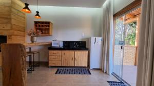 uma cozinha com um frigorífico e uma mesa com um micro-ondas em POUSADA JURERE DA CANASTRA em Vargem Bonita