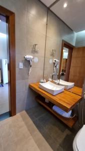 a bathroom with two sinks and a mirror at POUSADA JURERE DA CANASTRA in Vargem Bonita