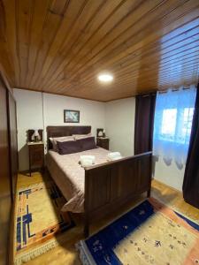 AlfeizerãoにあるA Casa Dos Avósの木製の天井が特徴のベッドルーム1室(ベッド1台付)