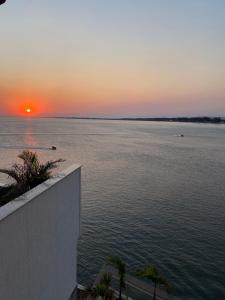 a view of the ocean at sunset from a house at Marambaia Mar in Rio de Janeiro