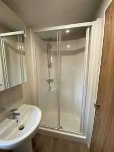 uma casa de banho com um chuveiro e um lavatório. em Coghurst Hall Holiday Home Sleeps 6, 2 bedrooms em Hastings
