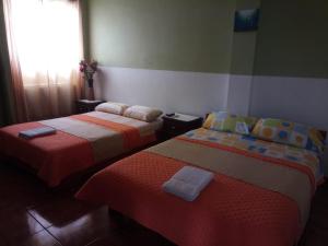 1 dormitorio con 2 camas y ventana en Stefany Hospedaje, en Puerto Ayora