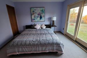 um quarto com uma cama grande e uma janela em Beautiful White Mountain Cottage with Hot Tub em Jefferson