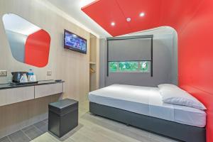 a bedroom with a bed with a red wall at Hotel 81 Lavender in Singapore