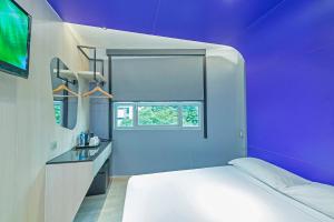 ein Schlafzimmer mit einem weißen Bett und einer lila Wand in der Unterkunft Hotel 81 Lavender in Singapur