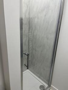 a shower with a glass door in a bathroom at Beautiful refurbished, self-contained apartment in Fife