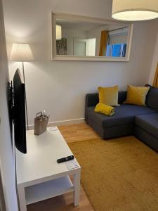 a living room with a blue couch and a tv at Beautiful refurbished, self-contained apartment in Fife