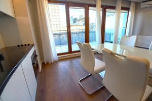 ワルシャワにあるerApartments Oxygen Residenceのキッチン(テーブル、椅子付)、大きな窓が備わります。