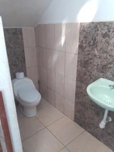 y baño con aseo y lavamanos. en Hostel Home Trotamundos, en Chachapoyas