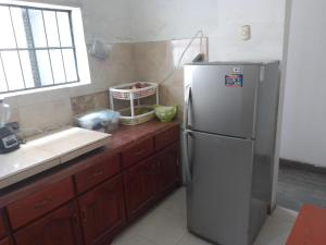 a kitchen with a stainless steel refrigerator and a sink at Hostel Home Trotamundos in Chachapoyas