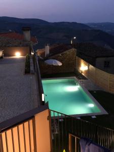 a swimming pool on top of a house at night at Castas do Douro in Tabuaço