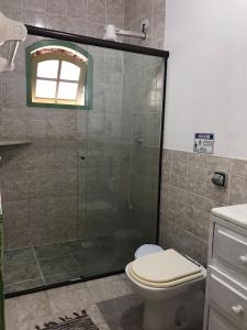 a bathroom with a shower with a toilet and a sink at Pousada Florescer in Paraty