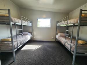 Zimmer mit 3 Etagenbetten und einem Fenster in der Unterkunft Levin TOP 10 Holiday Park in Levin