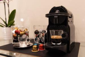 a coffee maker on a table with a cup of coffee at Quintus Luxury Suites in Rome +37 photos