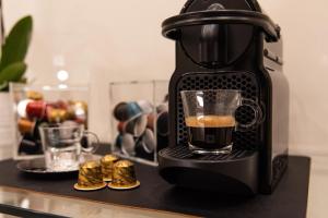 a coffee maker on a counter with a cup of coffee at Quintus Luxury Suites in Rome