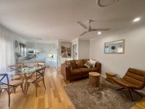 uma sala de estar com um sofá e uma mesa em The Sandy Villa 150 meters from Sawtell Beach em Sawtell
