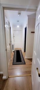 a hallway with a black and white rug on the floor at 2 Bedroom Apartment - Greater London in Dagenham
