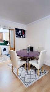 ein Esszimmer mit einem lila Tisch und Stühlen in der Unterkunft 2 Bedroom Apartment - Greater London in Dagenham
