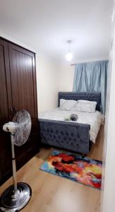 a bedroom with a bed with a fan and a rug at 2 Bedroom Apartment - Greater London in Dagenham