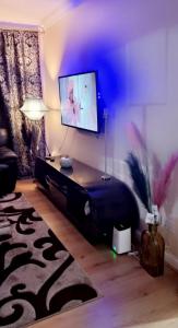 uma sala de estar com um sofá e uma televisão em 2 Bedroom Apartment - Greater London em Dagenham