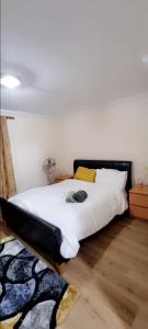 a bedroom with a bed with a black headboard at 2 Bedroom Apartment - Greater London in Dagenham