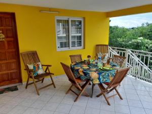 un tavolo da pranzo e sedie sul balcone di Villa Campêche a Bouillante