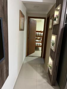 einen Flur mit einer Tür, die zu einem Zimmer führt in der Unterkunft Apartamento Só Alegria in Bombinhas