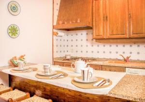 a kitchen with a table with plates and utensils on it at Refúgio do Vidoeiro in Geres