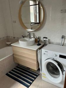 uma casa de banho com uma máquina de lavar roupa e um lavatório em Luminoso e accogliente appartamento a San Donato em San Donato Milanese