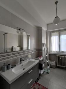 La salle de bains est pourvue d'un lavabo et d'un grand miroir. dans l'établissement Design apartment n. 41, à Trente