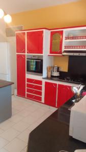 a kitchen with red cabinets and a stove top oven at Maison de campagne proche des plages in Sainte-Rose +23 photos