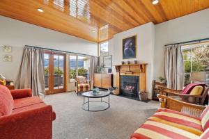 a living room with a couch and a fireplace at Lakeside Indulgence on Wilmot in Queenstown