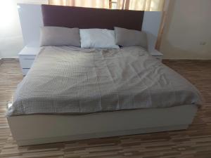 a large bed in a bedroom with a wooden floor at Masbella Hotel Ltd 