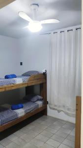 een kamer met 2 stapelbedden en een plafondventilator bij Hostel da Floresta in Vitória