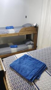 Habitación con 2 literas y alfombra azul. en Hostel da Floresta en Vitória